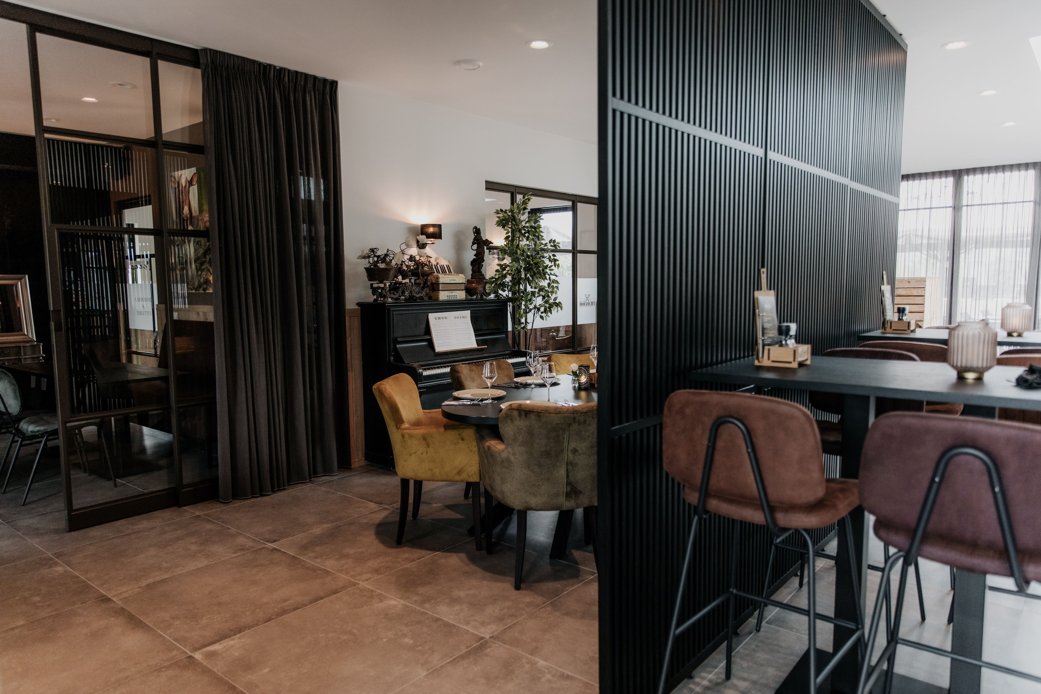 We hebben 5 houten roomdividers van 1060 mm breed en 2855 mm hoog in RAL 9005 geplaatst in dit restaurant.