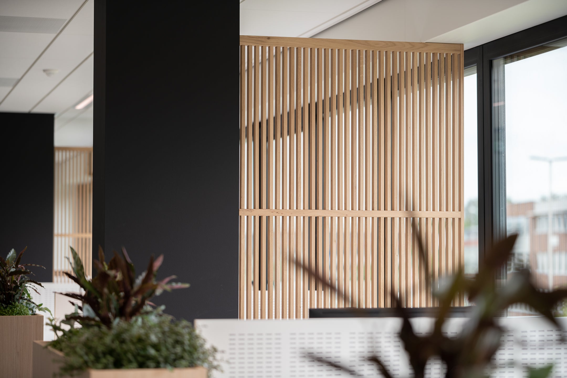 Houten scheidingswanden creëren een open en lichte werkplek, bevorderen samenwerking en bieden privacy in de kantoortuin.