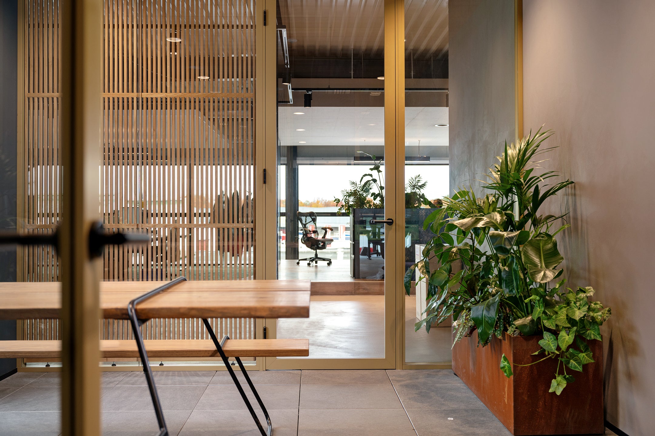 Glazen scheidingswanden met aluminium profielen en op maat gemaakte houten roomdividers voor een stijlvolle en functionele kantoorruimte.