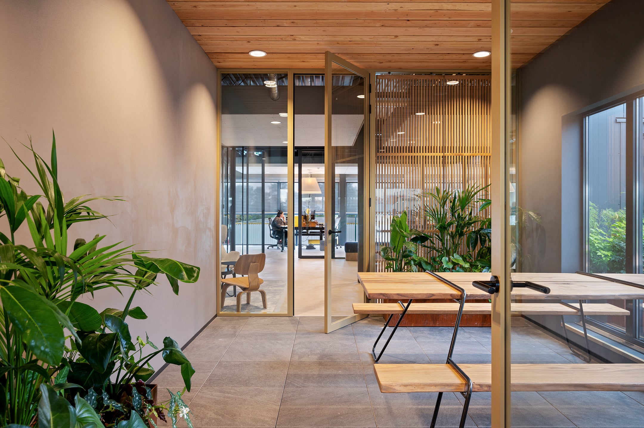 Glazen scheidingswanden met aluminium profielen en op maat gemaakte houten roomdividers voor een stijlvolle en functionele kantoorruimte.
