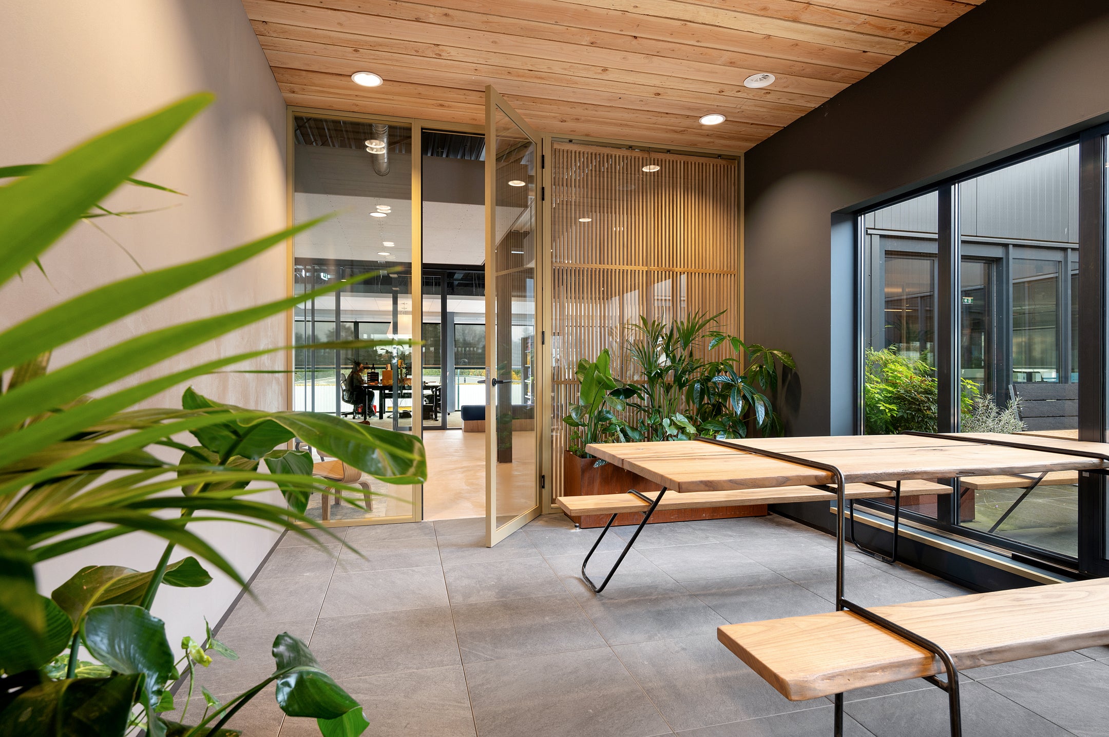 Glazen scheidingswanden met aluminium profielen en op maat gemaakte houten roomdividers voor een stijlvolle en functionele kantoorruimte.