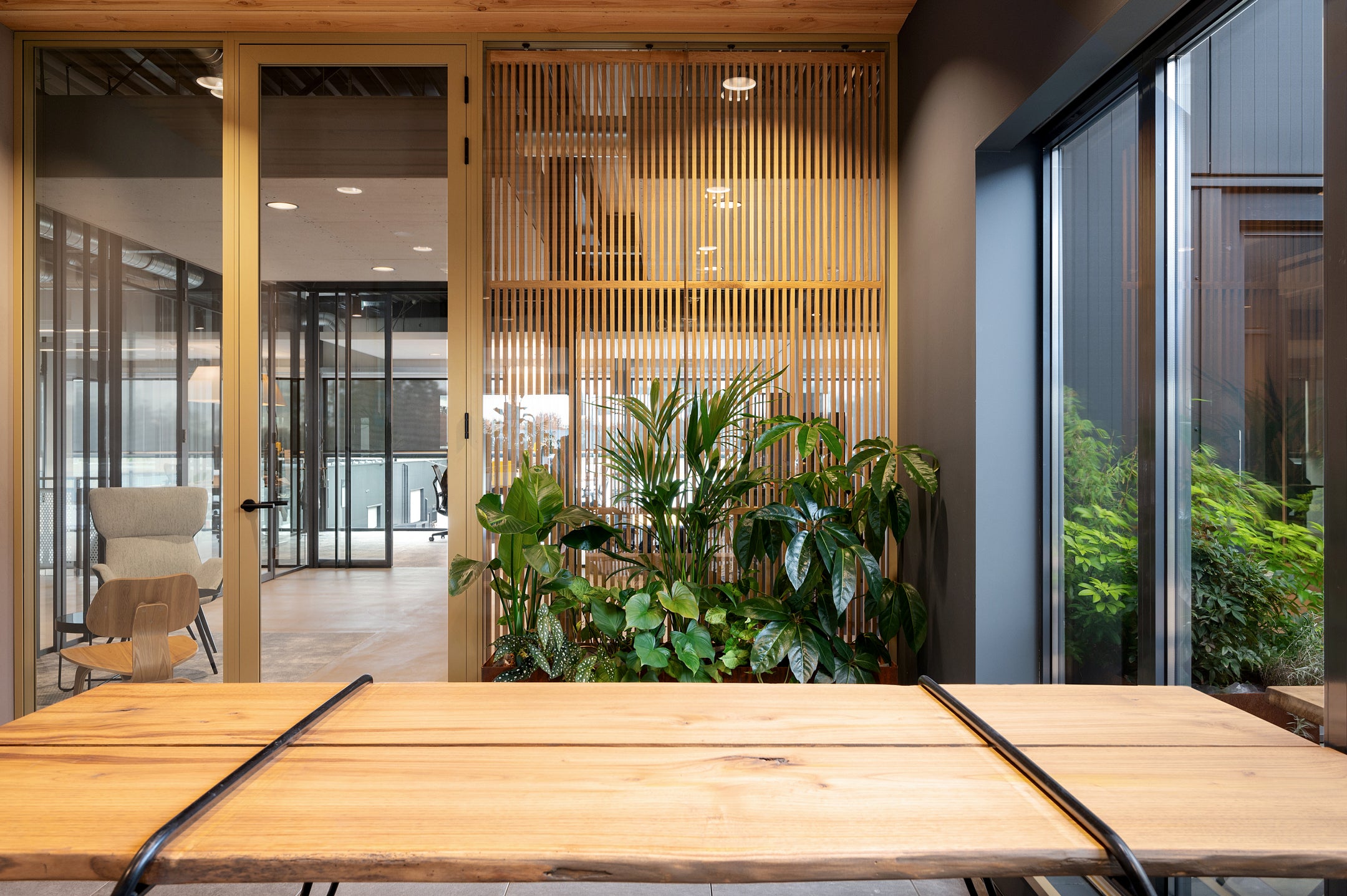 Glazen scheidingswanden met aluminium profielen en op maat gemaakte houten roomdividers voor een stijlvolle en functionele kantoorruimte.