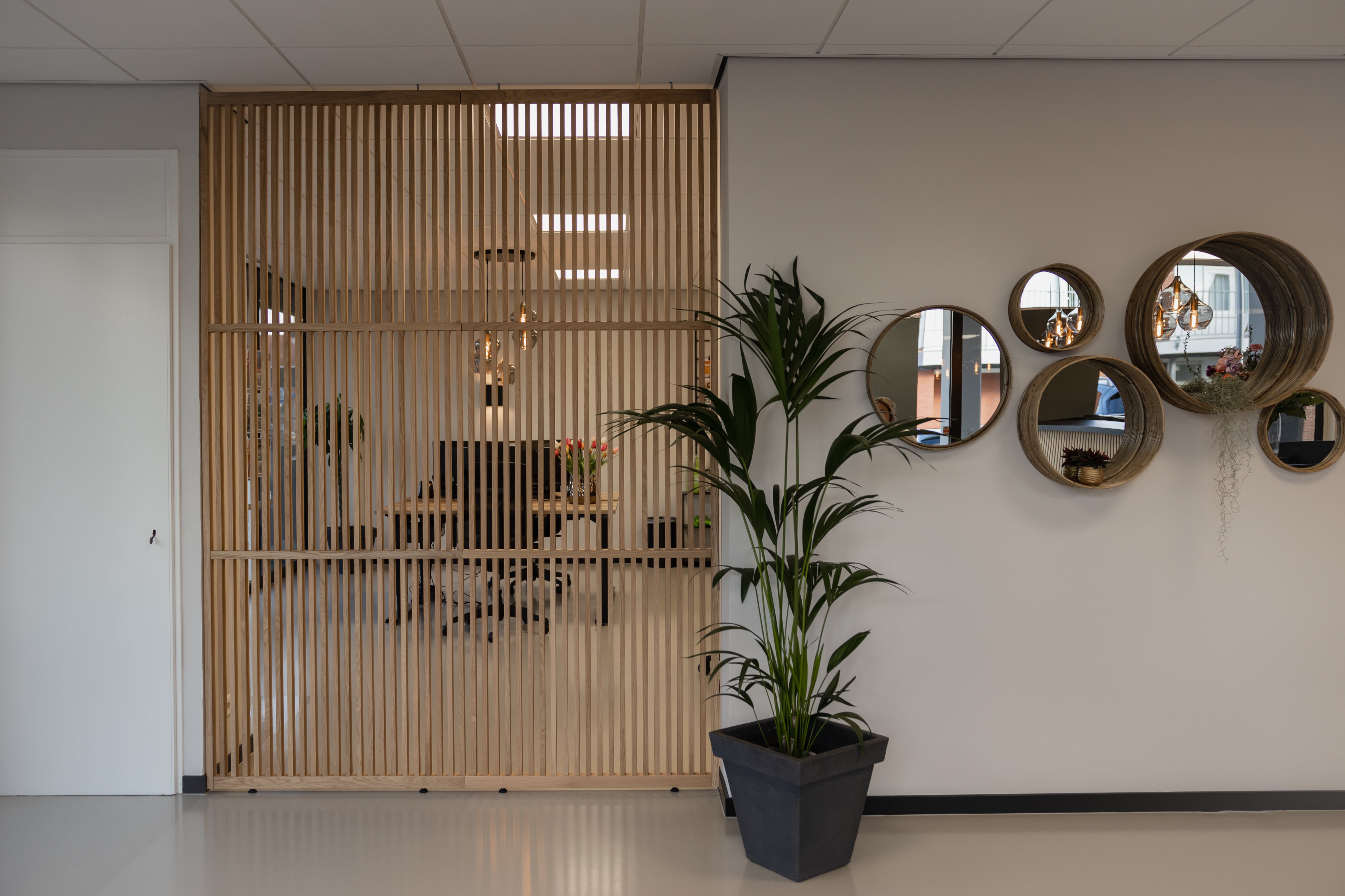 XL houten scheidingswand in een kantoor zorgt voor een elegante verdeling van werkruimtes, biedt privacy en behoudt een open, lichte sfeer in de ruimte.