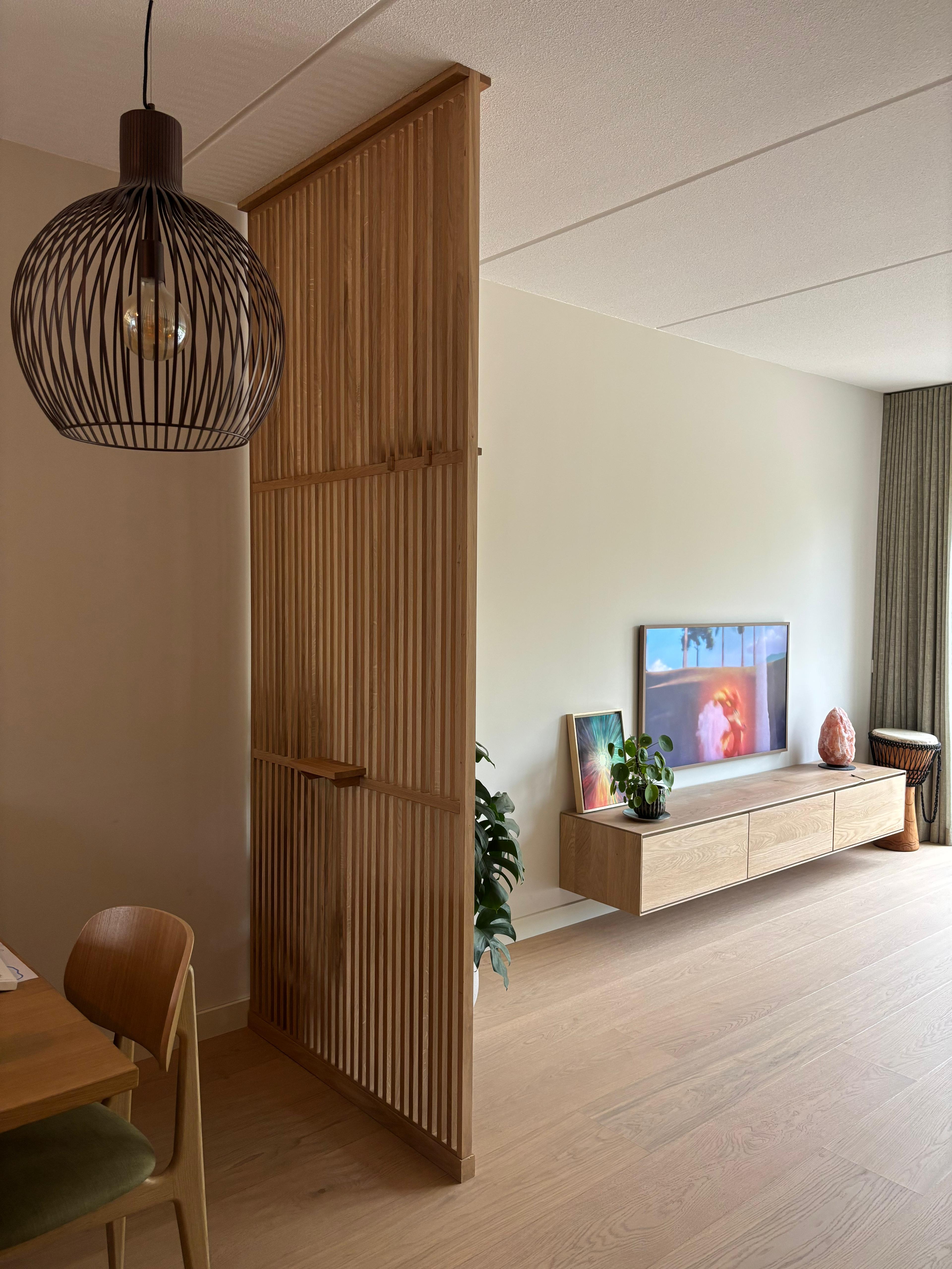 Kamerhoge massief eiken roomdivider tot aan het plafond als stijlvolle scheiding tussen eetkamer en woonkamer