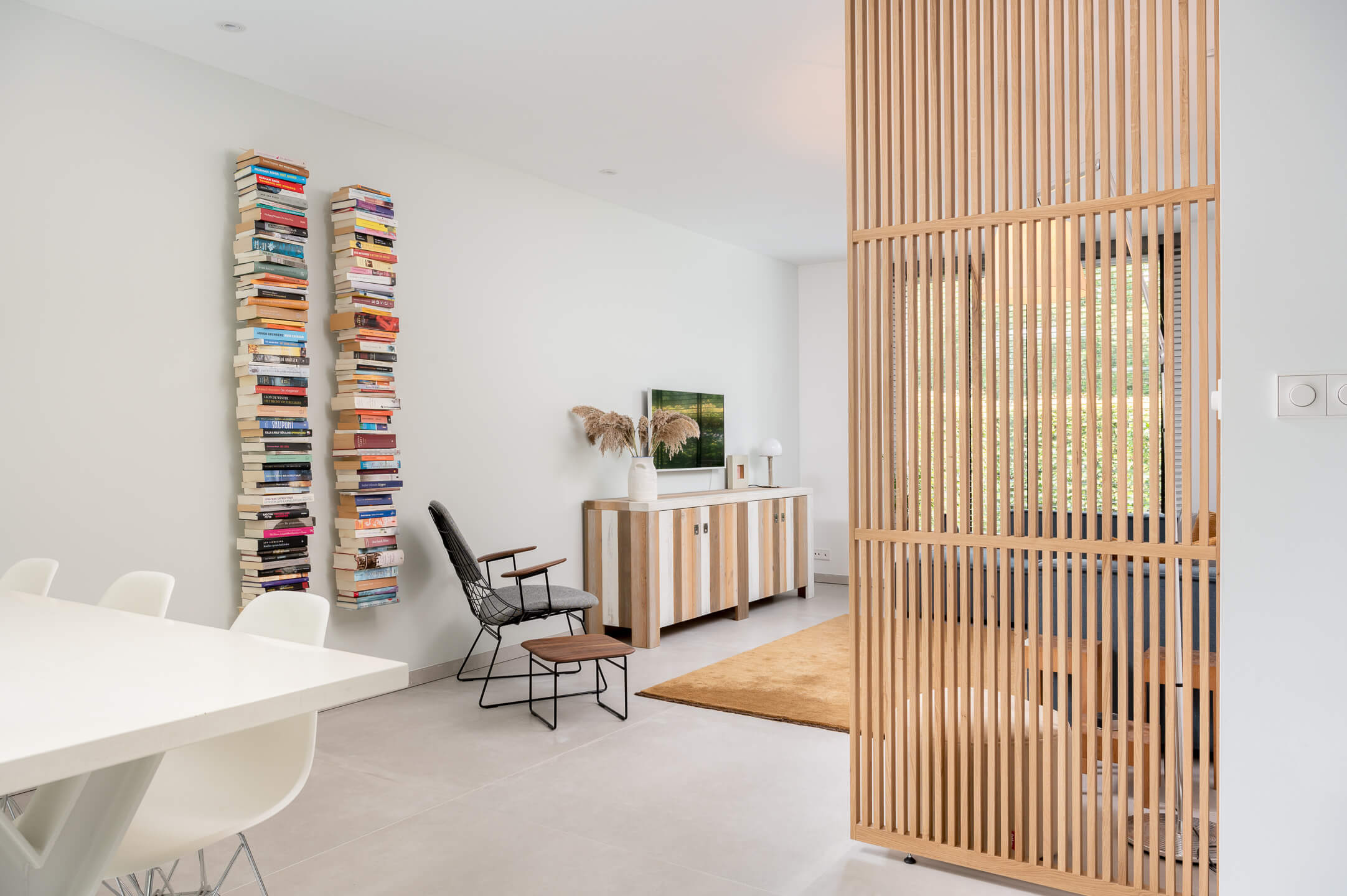 Luxe massief eiken roomdivider op maat geplaatst in een modern en licht woonkamer interieur.