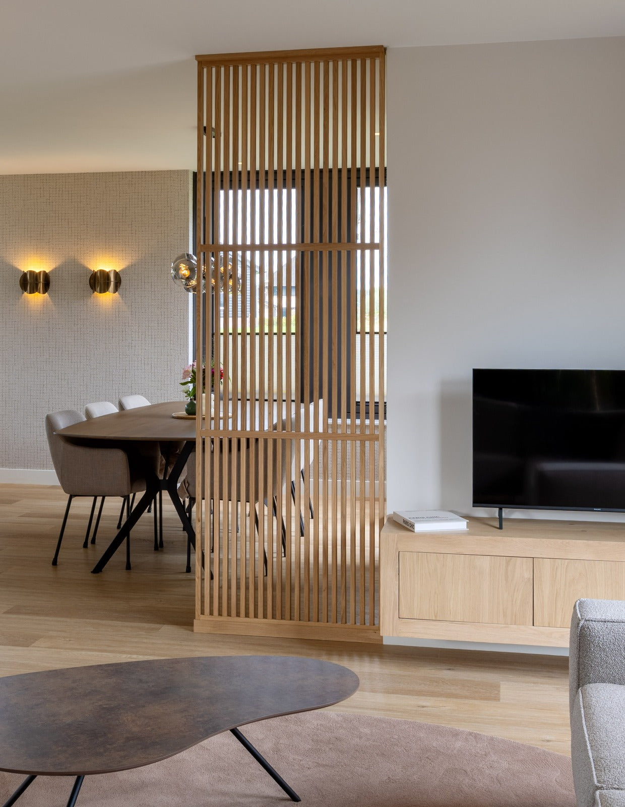 Kamerhoge houten roomdivider tot aan het plafond tussen woonkamer en eethoek