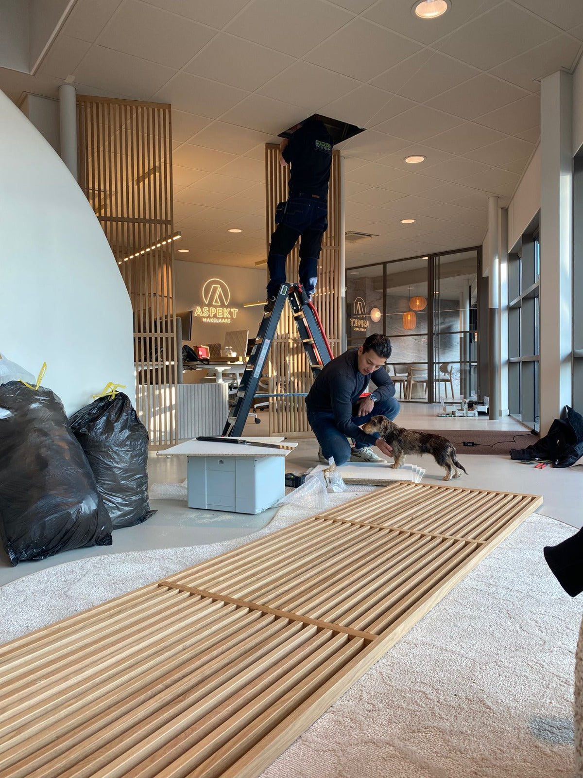 Voorbereiding van de montage van een maatwerk eiken roomdivider in het kantoor van Aspekt Makelaars